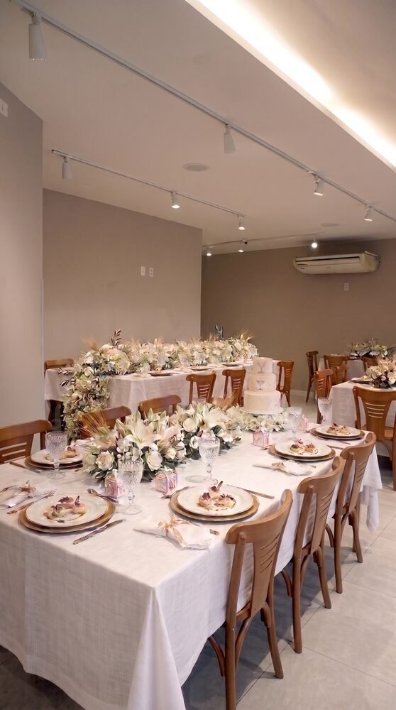 Mesa elegante com bolo em andares e arranjos florais no Terrazo, ambiente para chá revelação em Fortaleza, no Cocó